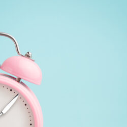 Pink alarm clock with fork and knife for hands for intermittent fasting | Reproductive Science Center of the SF Bay Area